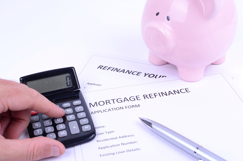 Person calculating mortgage options with a pink piggy bank