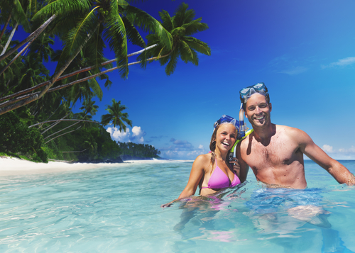 Couple snorkeling in blue water from getting perks from their credit card