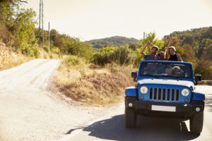 People riding in a blue jeep